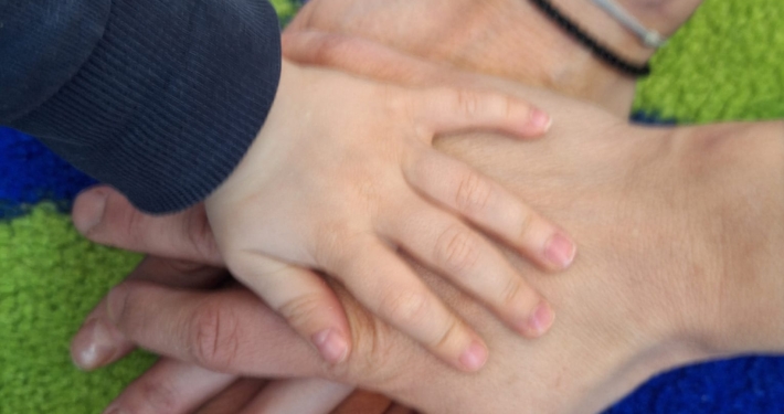 Danielas Gedanken zum 1. Juni - Internationaler Kindertag und Weltelterntag 1 eine Gruppe von übereinander liegenden Händen - ein Kind und zwei Erwachsene