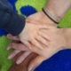 eine Gruppe von übereinander liegenden Händen - ein Kind und zwei Erwachsene